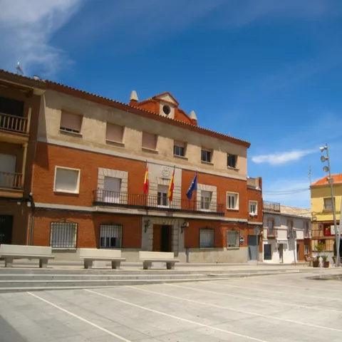 Plaza amplia con edificio institucional y bancos