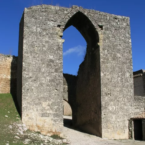 Arco gótico aislado sobre camino de tierra.
