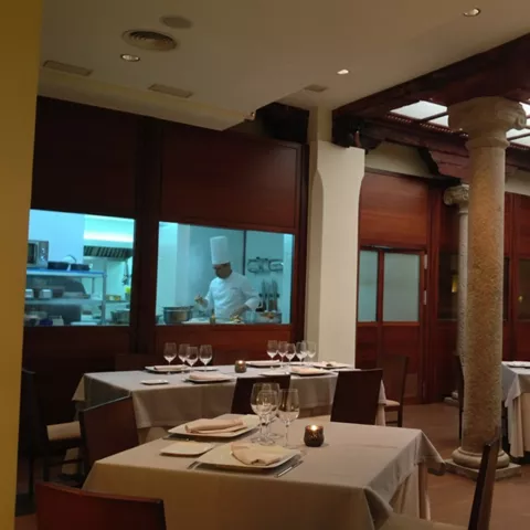 Comedor con cocina abierta y mesas iluminadas
