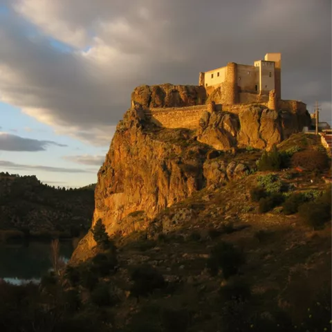 Fortaleza sobre peñasco al atardecer