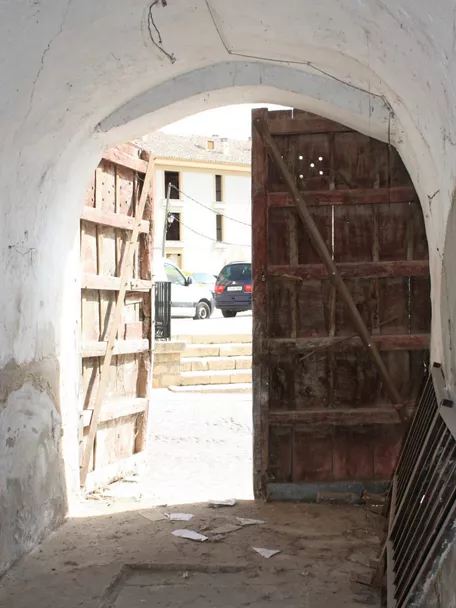 Acceso abovedado con puertas de madera abiertas.