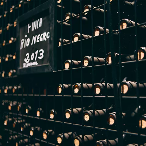 Botellas almacenadas en estanterías metálicas.