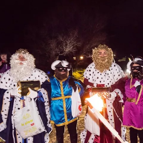 Personas disfrazadas con trajes festivos durante una celebración nocturna