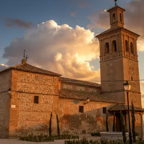 Iglesia de piedra con torre y árboles en primer plano