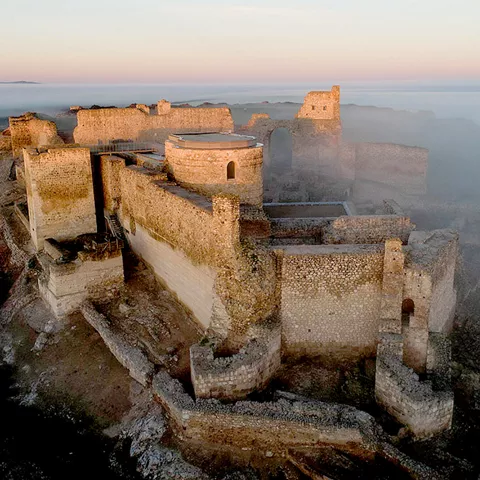 Fortaleza medieval vista desde el aire entre brumas matinales