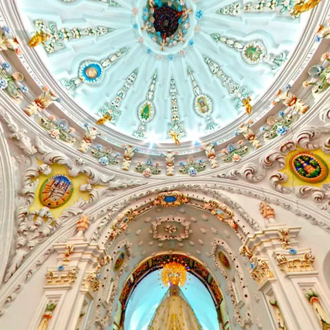 Cúpula interior decorada con relieves y detalles policromados.