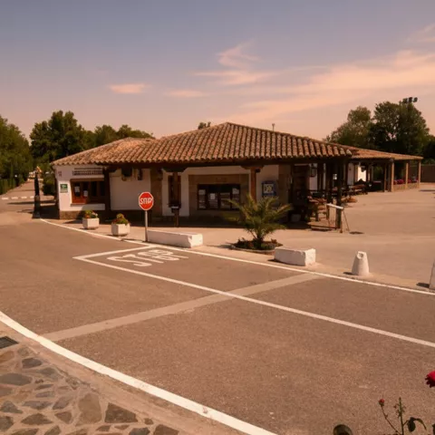 Edificio principal de complejo turístico con calles internas y señalización vial.