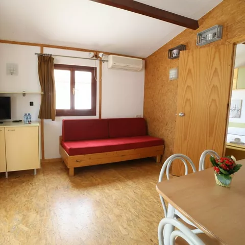 Sala de estar de bungalow con sofá rojo y mesa