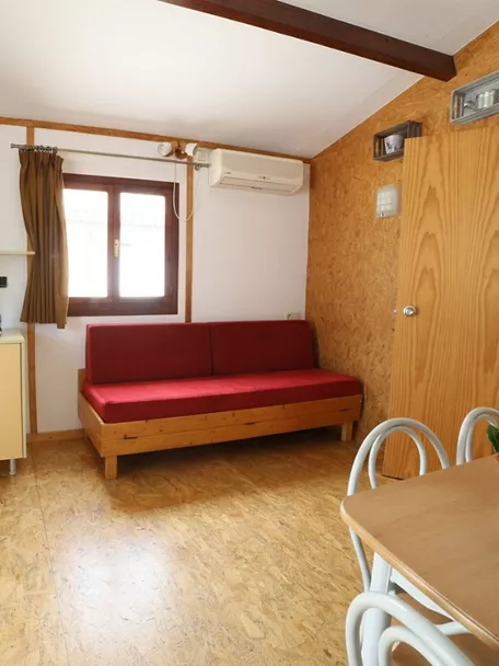 Sala de estar de bungalow con sofá rojo y mesa