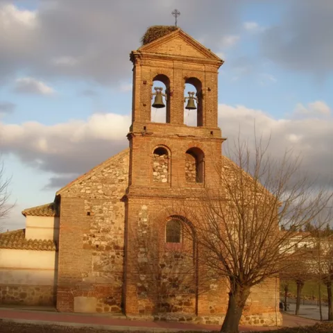 Espadaña de ladrillo iluminada al atardecer