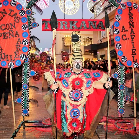 Participante disfrazado con estandartes y maquillaje teatral