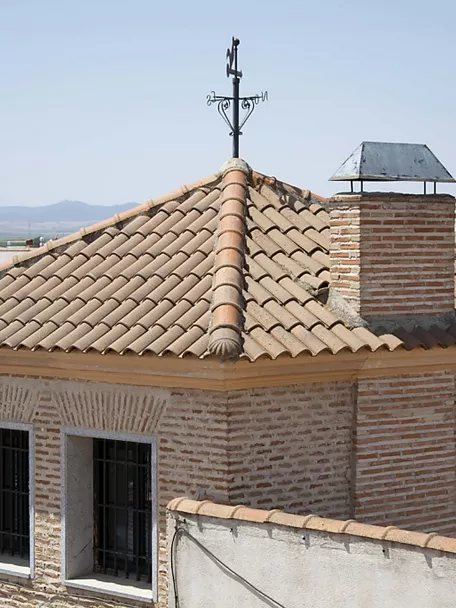 Torre de ladrillo con tejado de teja y veleta