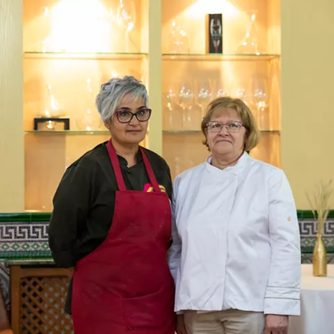 Cocina con dos mujeres uniformadas en el comedor
