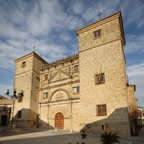 Fachada de palacio de piedra con dos torres y portada monumental