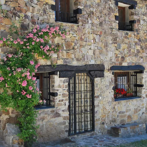 Casa tradicional de piedra con fachada decorada con flores.