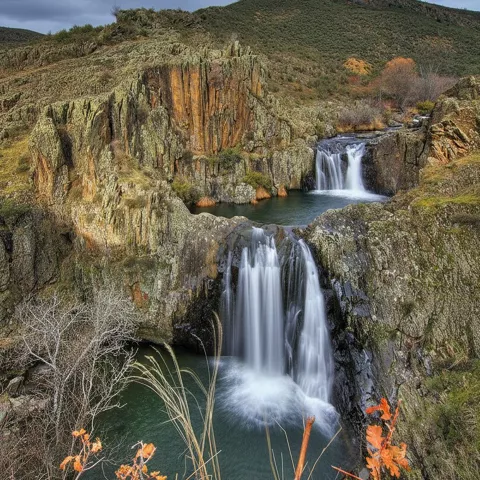 Cascada escalonada en paisaje montañoso.
