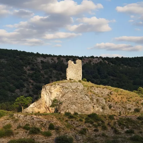 Restos de torre defensiva sobre un cerro rocoso.