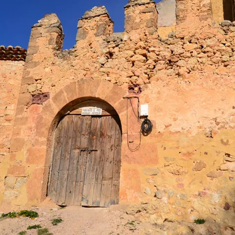 Puerta de madera en arco de piedra antigua.