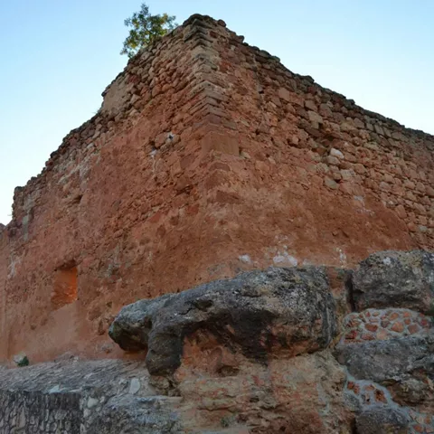 Muralla de castillo medieval de piedra rojiza