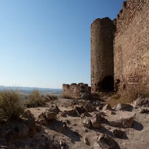 Murallas de piedra con paisaje agrícola al fondo desde lo alto