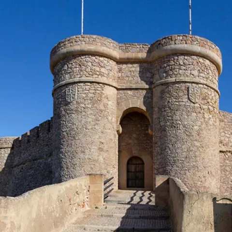 Puerta fortificada flanqueada por dos torres circulares de piedra