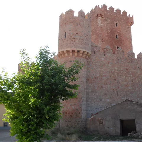 Torre circular con muralla almenada.