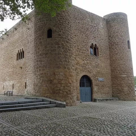Edificio fortificado con patio de adoquines.