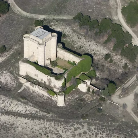 Vista aérea de castillo con murallas y caminos rurales