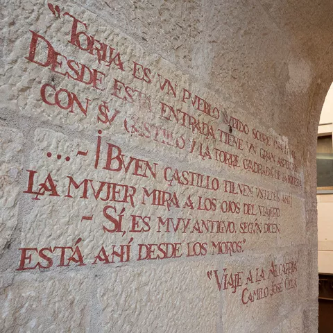 Inscripción en muro de piedra bajo arco.