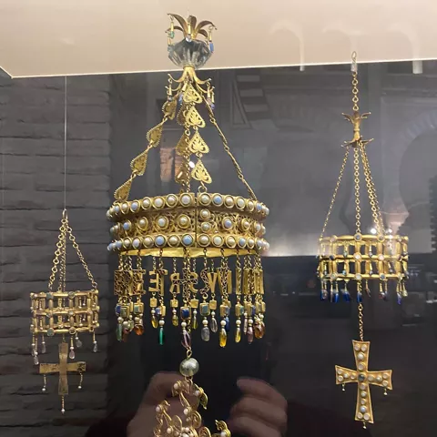Joyas y piezas colgantes de oro expuestas en una vitrina de museo.
