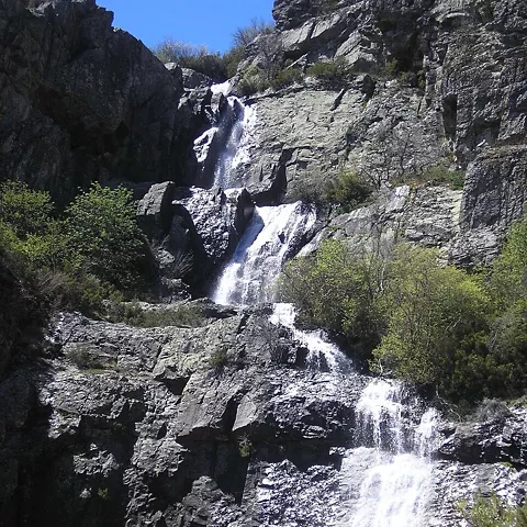 Cascada natural entre paredes rocosas.