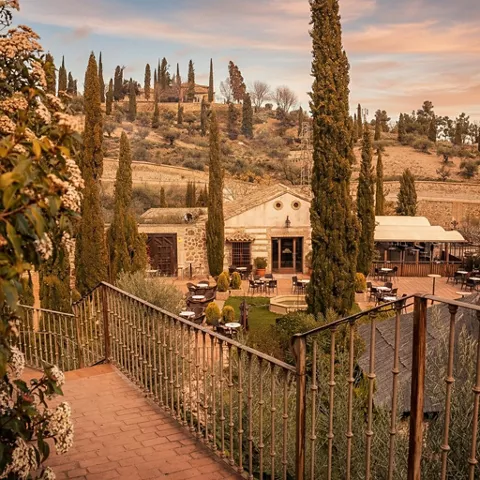 Vista elevada de jardines y terrazas entre cipreses.