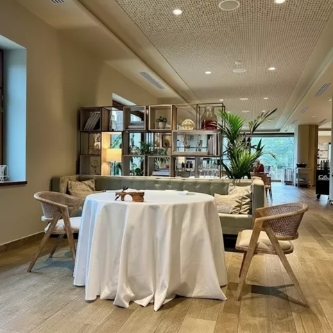 Salón restaurante luminoso con mesas redondas y decoración natural