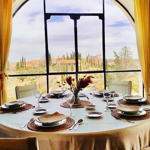 Mesa redonda frente a gran ventanal con vistas