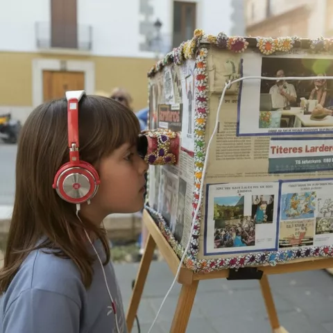 Niña con auriculares frente a instalación cultural interactiva