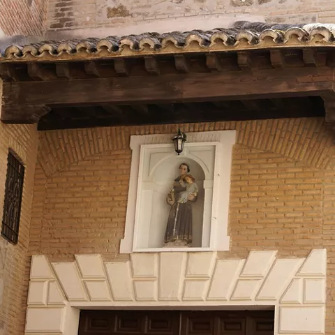 Detalle de hornacina con imagen religiosa sobre portada.