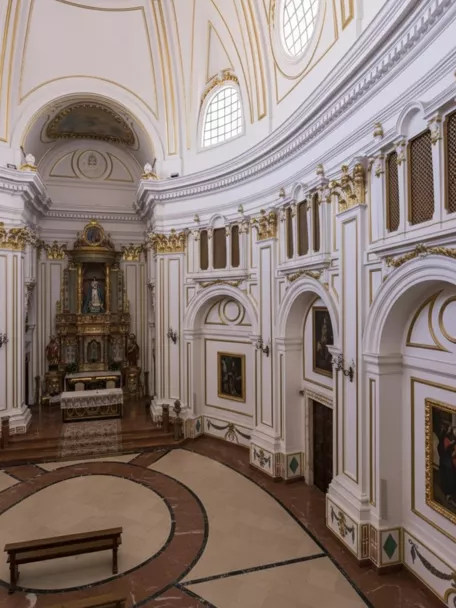 Nave circular con altares y pinturas murales.