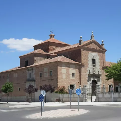 Conjunto de iglesia y edificio anexo de ladrillo visto en esquina urbana.