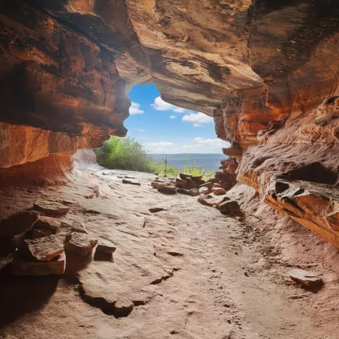 Cueva natural excavada en roca con abertura al paisaje exterior