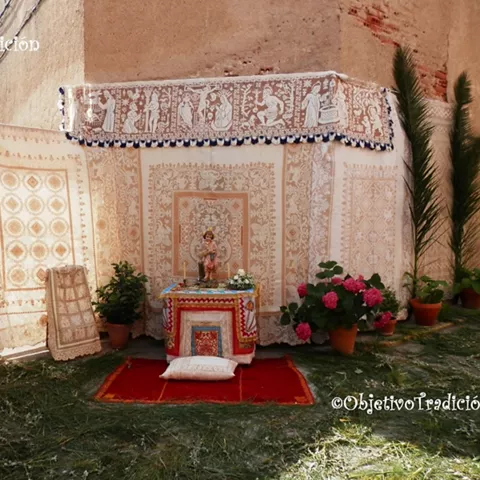 Pequeño altar decorado con telas bordadas, flores y plantas