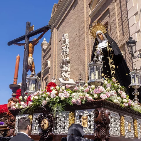 Cristo yacente sobre urna con cirios.