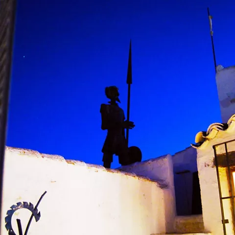 Escultura metálica recortada sobre cielo nocturno azul