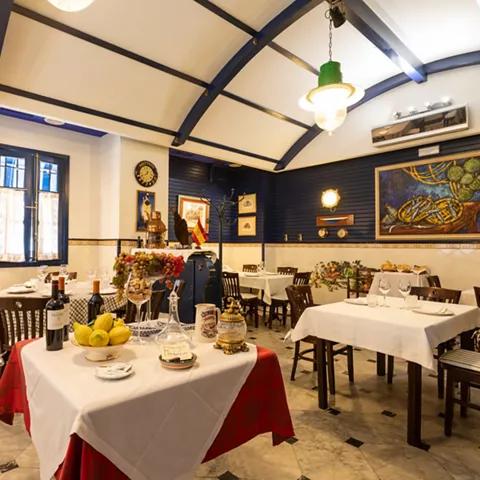 Salón decorado con cerámica azul y mesas vestidas