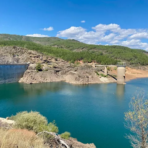 Vista lateral de presa y torre sobre el agua.