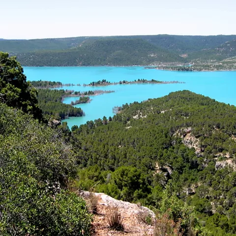 Lago de aguas turquesas rodeado de montes.
