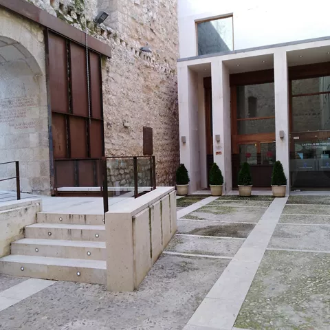 Entrada con escaleras y puerta acristalada.