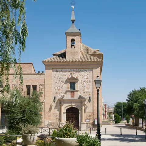 Iglesia de piedra junto a plaza con macetas