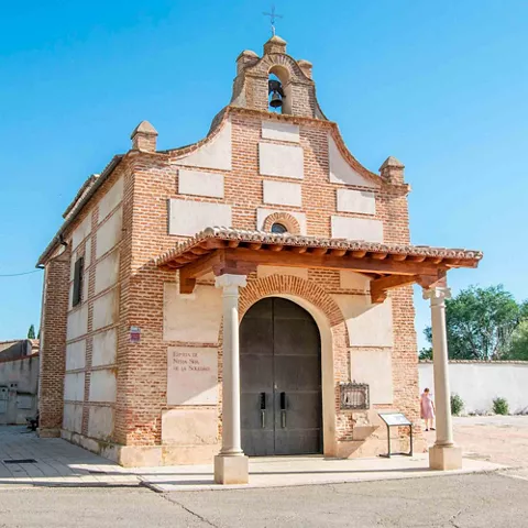 Ermita de ladrillo con pórtico y campana.