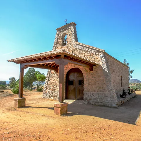 Pequeña ermita de piedra en un entorno rural.