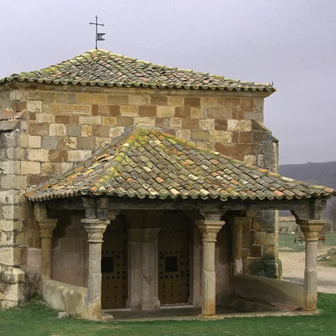 Ermita románica en paisaje rural.